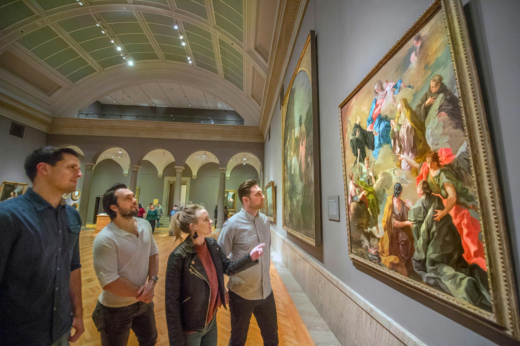 Four adults viewing a painting in the galleries